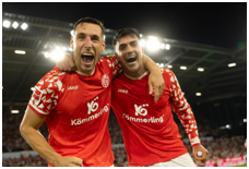 Dominik Kohr und Nadiem Amiri mit KÖMMERLING-Trikots jubeln in die Kamera