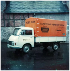 Firmenfahrzeug mit GEALAN Logo vor einem Fachwerkgebäude