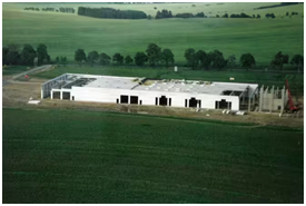 Luftaufnahme eines Industriegebäudes mit umliegenden Grünflächen