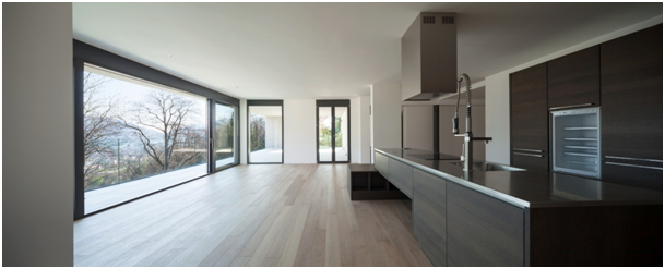 Küche mit großen Panoramafenstern und Tür mit Blick auf eine Hügellandschaft