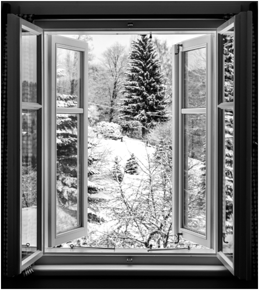 Geöffnetes Winterfenster mit Blick auf verschneite Tannen und Bäume